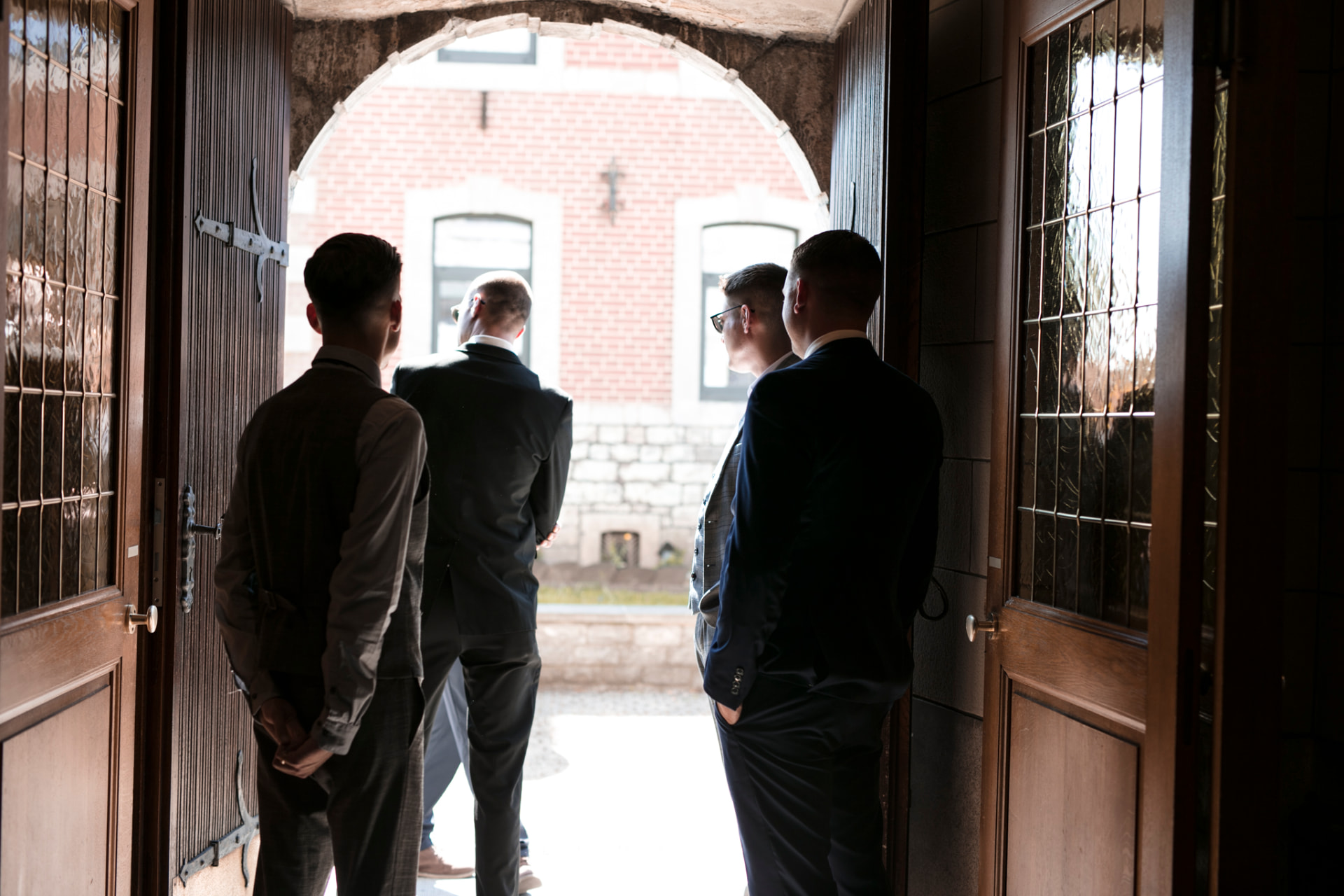 Gäste warten im Kirchenportal — Hochzeitsreportage Belgien