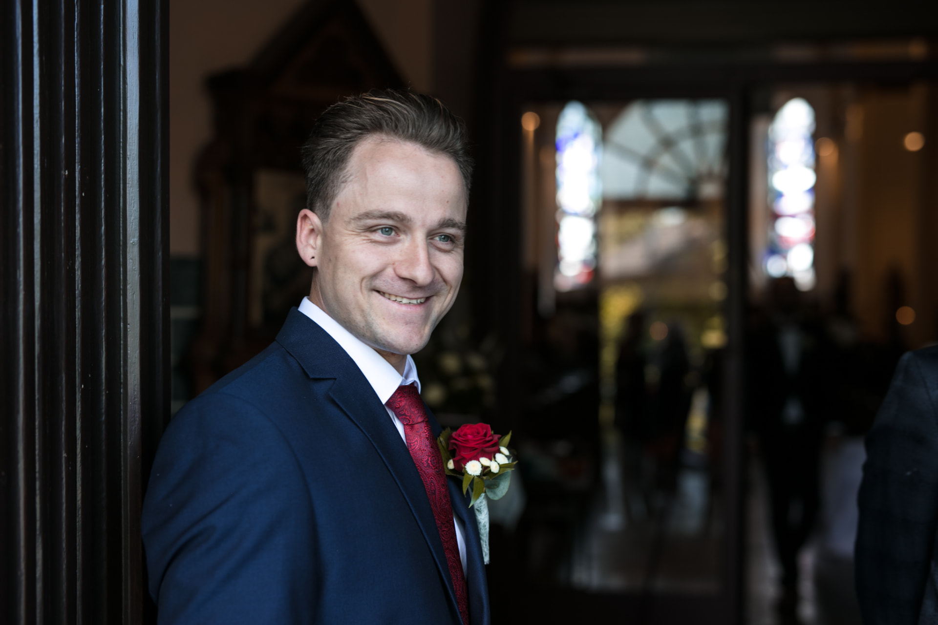 Bräutigam an der Kirchentür — Hochzeitsfotografie Ostbelgien